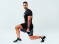 Uomo con manubri esegue affondi, un esercizio che rientra nel concetto di AMRAP (As Many Reps As Possible).