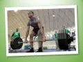 Uomo in palestra solleva bilanciere carico. Allenamento intenso per il rpe palestra.
