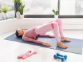Donna esegue hip thrust con elastico per i glutei, scoprendo i benefici di un allenamento mirato per tonificare e rafforzare.