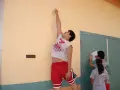 Ragazzo esegue un sargent test, allungandosi verso un segno sul muro. Altri ragazzi registrano i risultati.