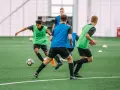 Giovani calciatori in allenamento, con pettorine verdi e blu, corrono su un campo sintetico. L'intensità dell'allenamento richiede un **aerobico alto**.