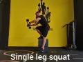 Uomo esegue squat monopodalico con manubri, allenamento per la forza e l'equilibrio.
