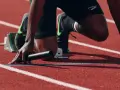 Atleta in posizione di partenza, pronto a scattare. La concentrazione è massima, un vero allenamento mentale prima della gara.