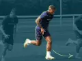 Three soccer players in training gear running on a field, with the central player in focus.