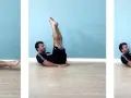 Uomo esegue leg raise a terra gambe tese, sollevando le gambe dritte verso l'alto e poi abbassandole lentamente.