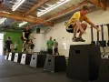 Allenamento di pliometria nel calcio: atleti saltano su box in palestra per migliorare esplosività e agilità.