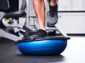 Allenamento in palestra con un piede su una palla BOSU per migliorare la stabilità dell'articolazione talocrurale.