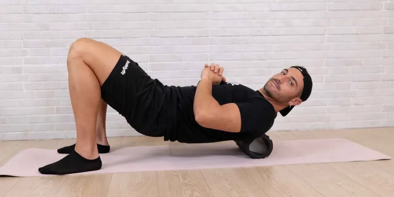 Uomo con foam roller sotto la schiena, per alleviare il dolore gambe dopo allenamento.