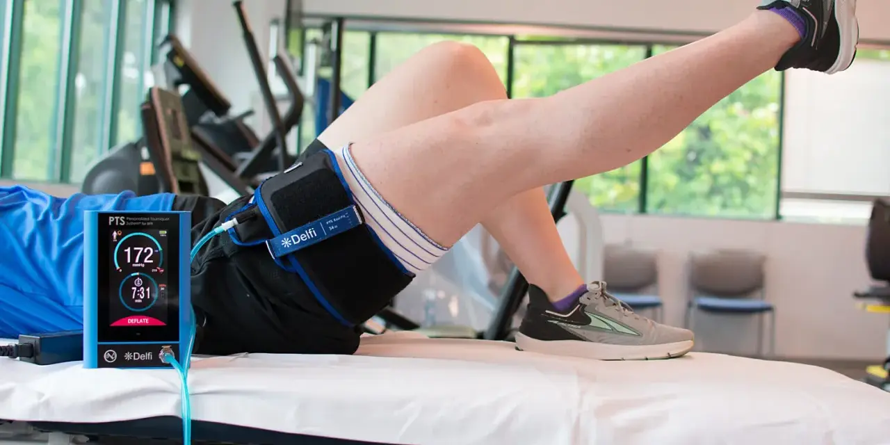 Persona che esegue un esercizio con un dispositivo Delfi per il **blood flow restriction**.