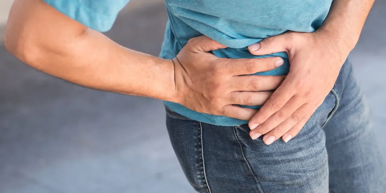 Uomo con mano sull'anca, soffre di coxalgia. Speranza di guarigione.