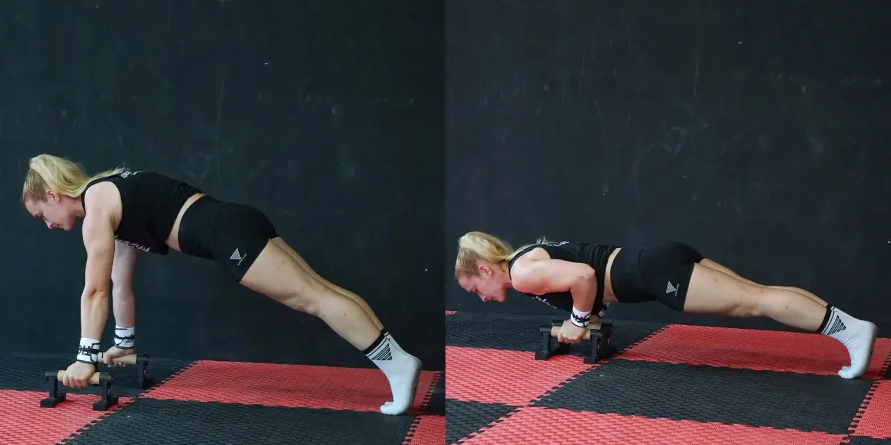 Donna esegue push up con maniglie, concentrata sul movimento.
