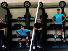 Uomo esegue un countermovement jump in palestra, guidato da un istruttore.