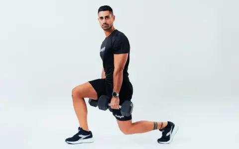 Uomo con manubri esegue affondi, un esercizio che rientra nel concetto di AMRAP (As Many Reps As Possible).