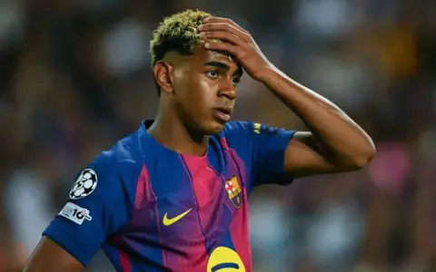 Giovane calciatore del Barcellona con la mano sulla fronte, forse riflette su quanto si allenano i calciatori per raggiungere questi livelli.