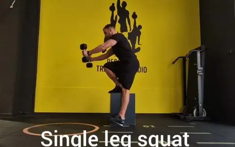 Uomo esegue squat monopodalico con manubri, allenamento per la forza e l'equilibrio.
