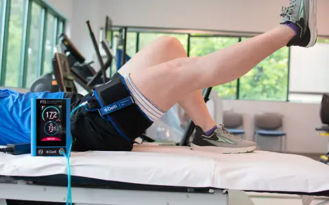 Persona che esegue un esercizio con un dispositivo Delfi per il **blood flow restriction**.