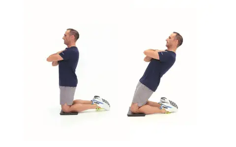 Uomo in ginocchio, braccia conserte, esegue un movimento eccentrica lenta di flessione del busto all'indietro.