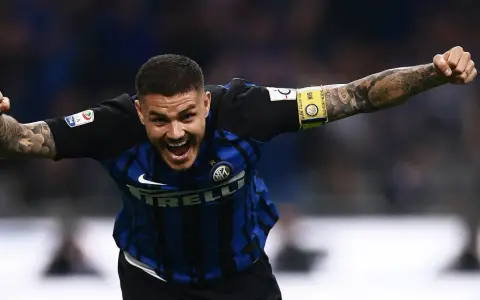Calciatore esultante con le braccia aperte, mostrando quanto corre un calciatore in una partita. Tatuaggi visibili sul braccio.