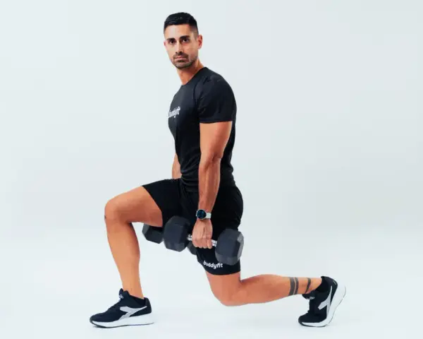 Uomo con manubri esegue affondi, un esercizio che rientra nel concetto di AMRAP (As Many Reps As Possible).