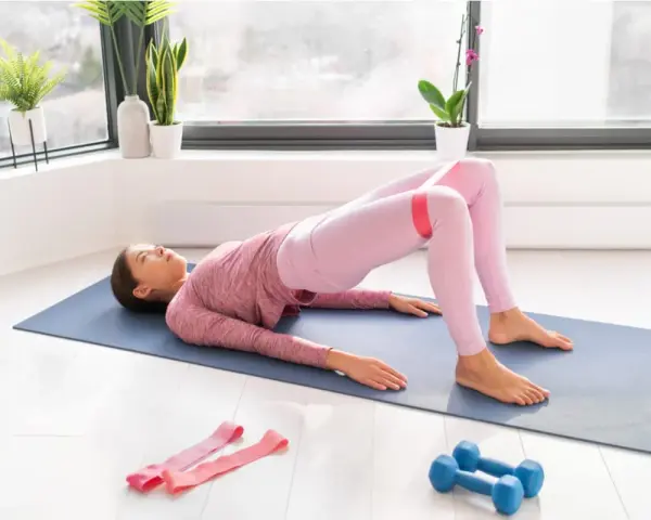 Donna esegue hip thrust con elastico per i glutei, scoprendo i benefici di un allenamento mirato per tonificare e rafforzare.