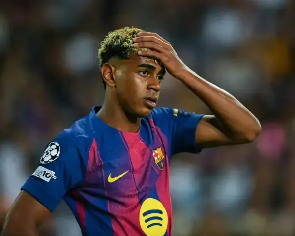 Giovane calciatore del Barcellona con la mano sulla fronte, forse riflette su quanto si allenano i calciatori per raggiungere questi livelli.