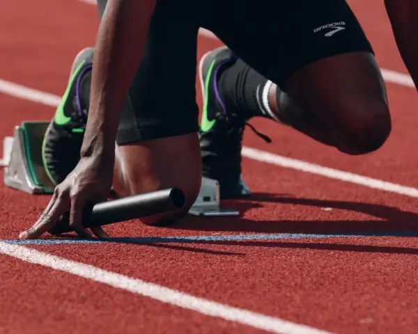 Atleta in posizione di partenza, pronto a scattare. La concentrazione è massima, un vero allenamento mentale prima della gara.