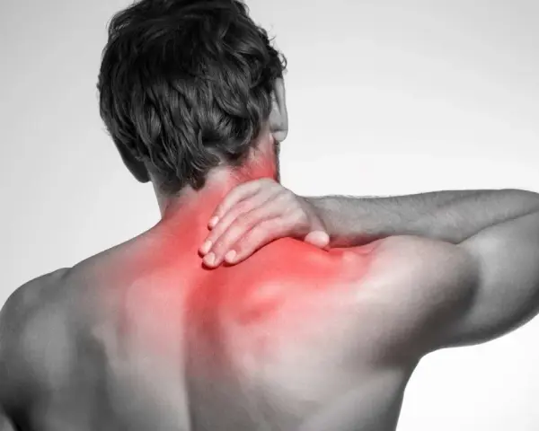 Uomo con mano sul collo, evidenziato in rosso il dolore ai muscoli del collo e delle spalle.