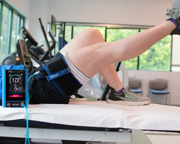 Persona che esegue un esercizio con un dispositivo Delfi per il **blood flow restriction**.