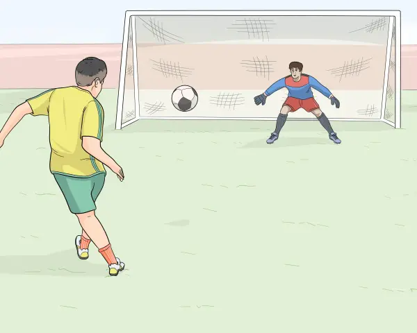 Ragazzo in maglia gialla pronto a calciare la palla verso la porta, con il portiere in posizione.