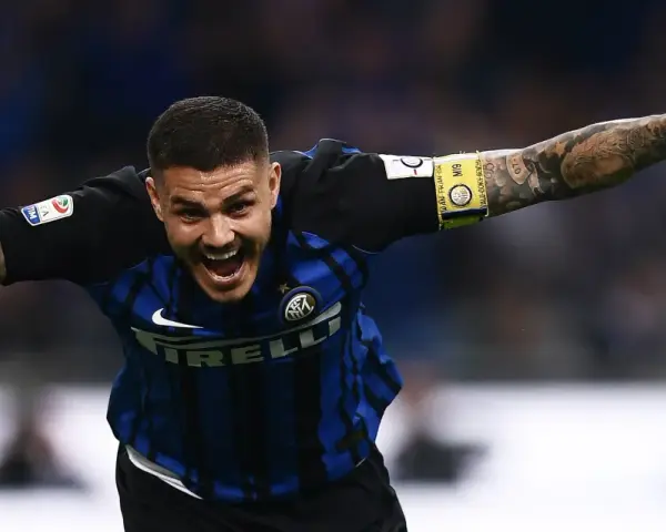 Calciatore esultante con le braccia aperte, mostrando quanto corre un calciatore in una partita. Tatuaggi visibili sul braccio.