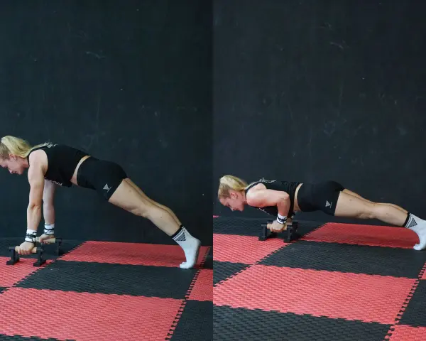 Donna esegue push up con maniglie, concentrata sul movimento.