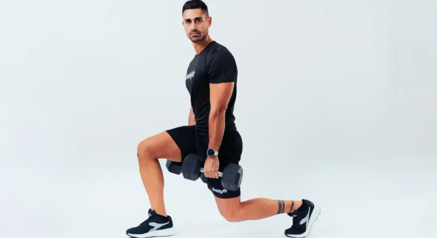 Uomo con manubri esegue affondi, un esercizio che rientra nel concetto di AMRAP (As Many Reps As Possible).