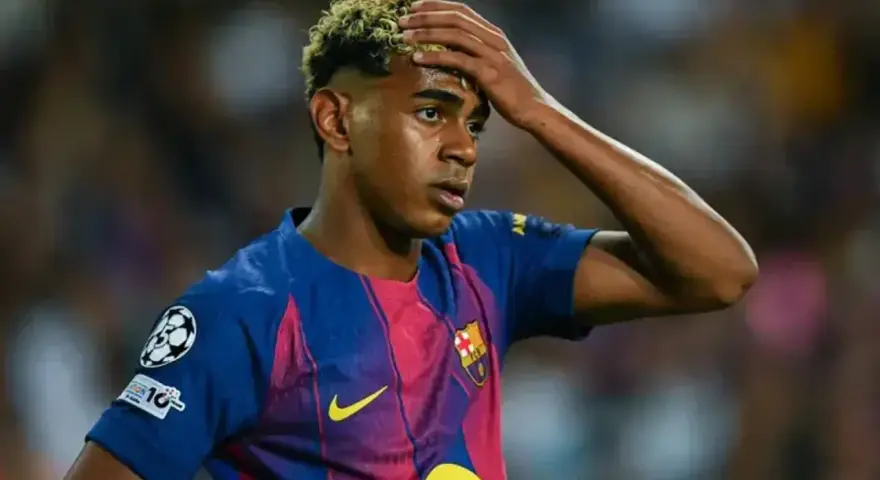 Giovane calciatore del Barcellona con la mano sulla fronte, forse riflette su quanto si allenano i calciatori per raggiungere questi livelli.