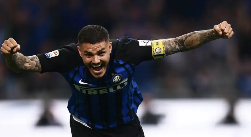 Calciatore esultante con le braccia aperte, mostrando quanto corre un calciatore in una partita. Tatuaggi visibili sul braccio.