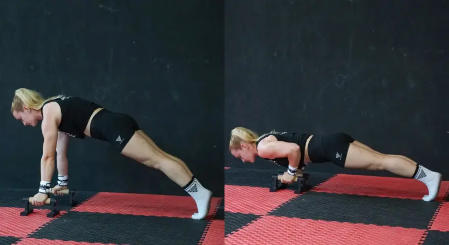 Donna esegue push up con maniglie, concentrata sul movimento.
