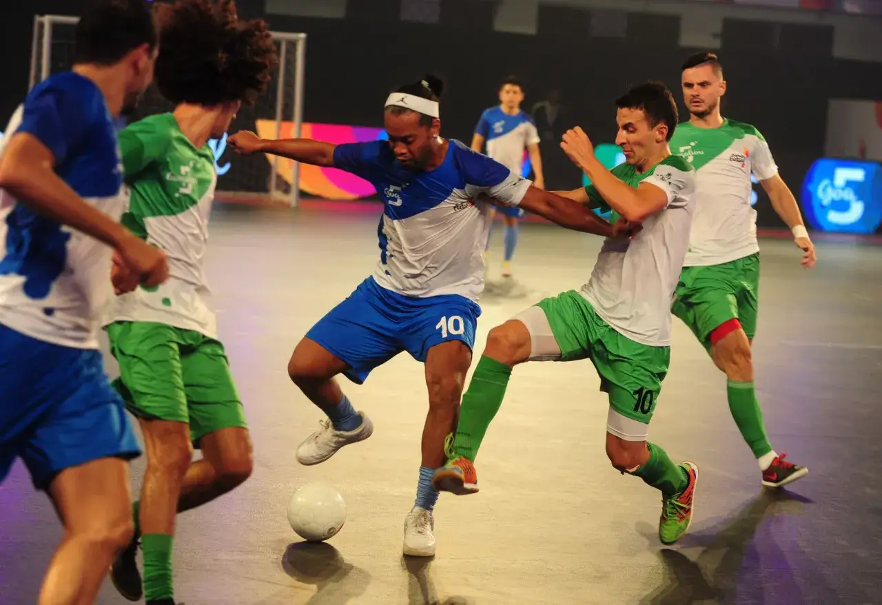 Giocatori di futsal in azione, con un pallone al centro. La velocità e l'agilità sono fondamentali in questo sport, scopri cos'è il futsal!