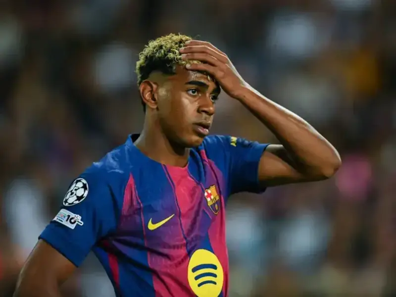 Giovane calciatore del Barcellona con la mano sulla fronte, forse riflette su quanto si allenano i calciatori per raggiungere questi livelli.
