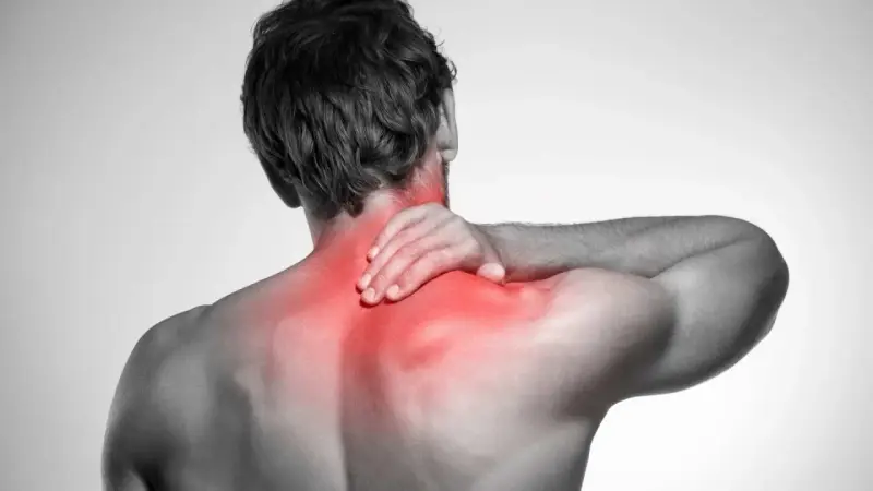 Uomo con mano sul collo, evidenziato in rosso il dolore ai muscoli del collo e delle spalle.